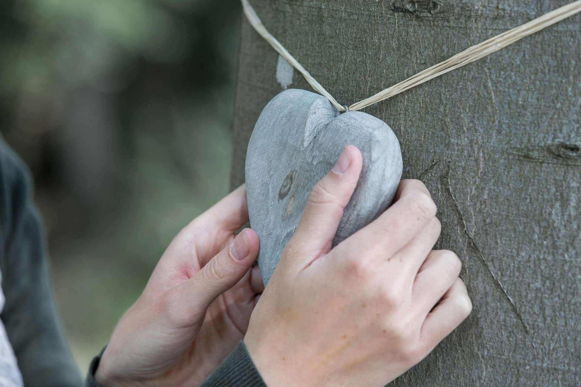 Ein graues Herz an einem Gedenkbaum